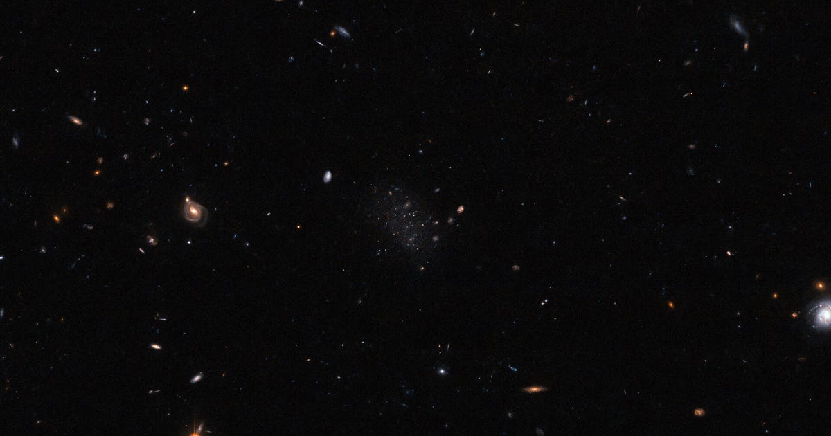 A sneaky galaxy lurks on this Hubble symbol. Are you able to spot it? 3